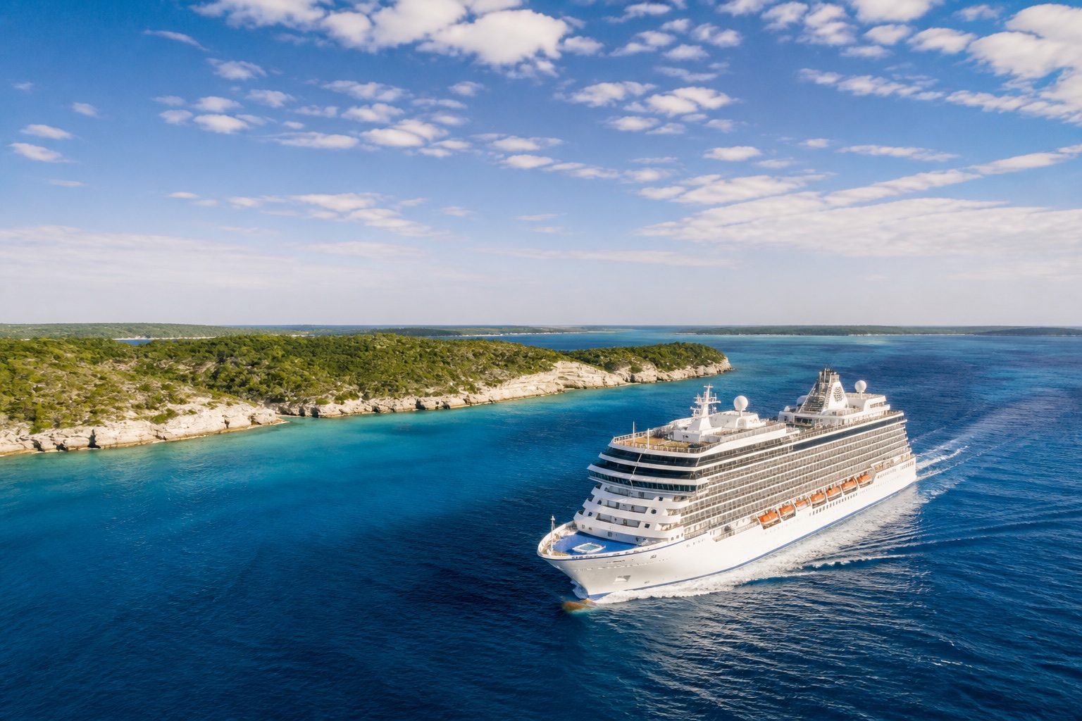 An unbranded cruise ship sailing in clear Caribbean water near a green island