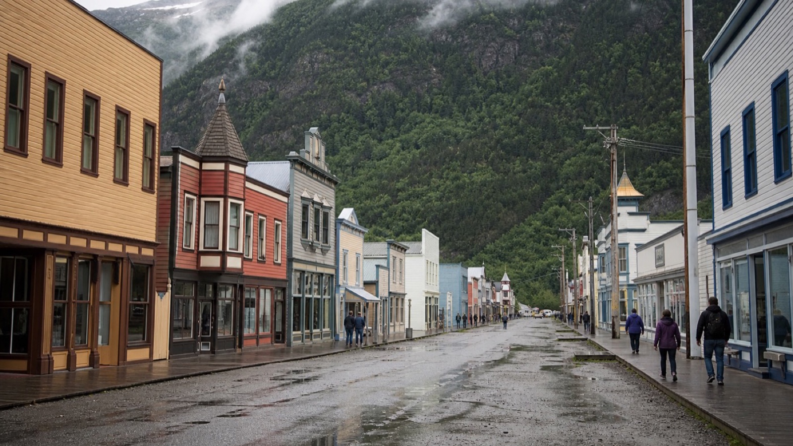 Historic Skagway streets beneath steep forested mountains after rain