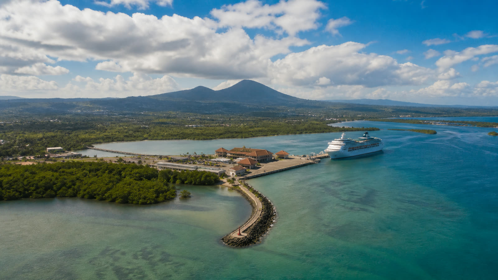 Benoa cruise harbor with an unbranded ship, low terminal buildings and tropical coastline