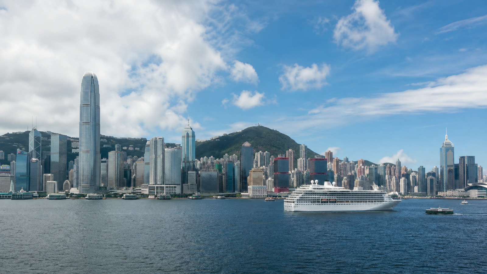 Hong Kong cruise terminal with an unbranded ship and the dense skyline at realistic scale