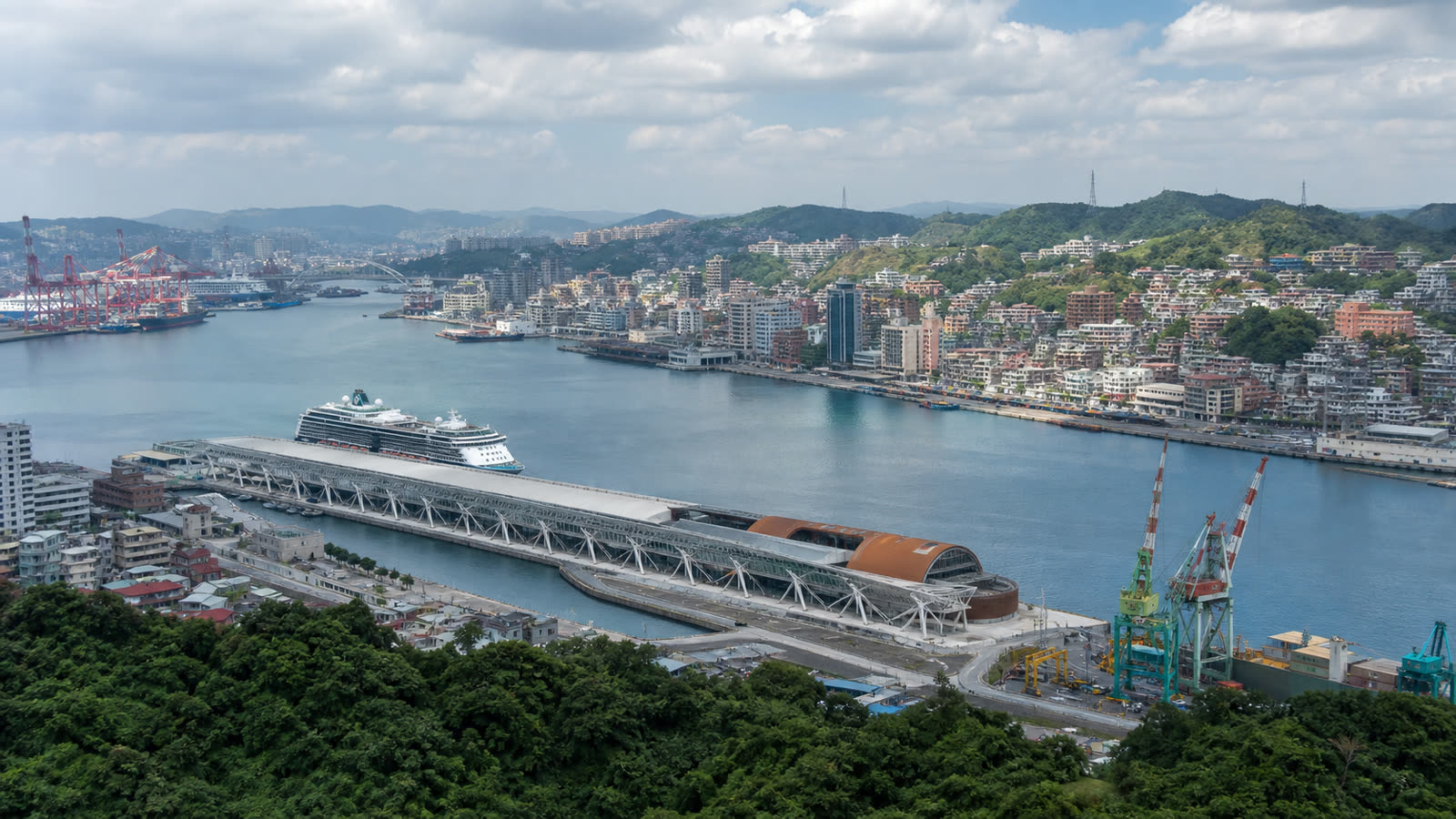 Keelung cruise harbor with an unbranded ship, working port and green hills