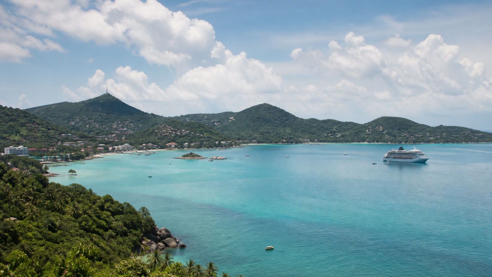 Unbranded cruise ship anchored offshore from Ko Samui with tender boats and tropical hills