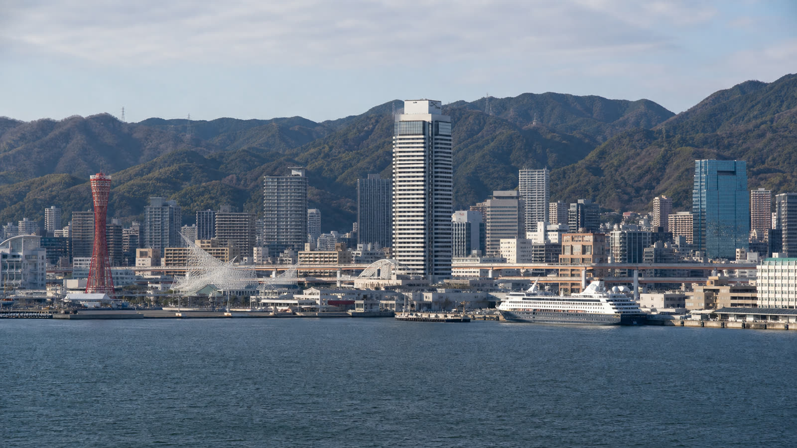 Kobe cruise terminal and waterfront with an unbranded ship and Mount Rokko beyond