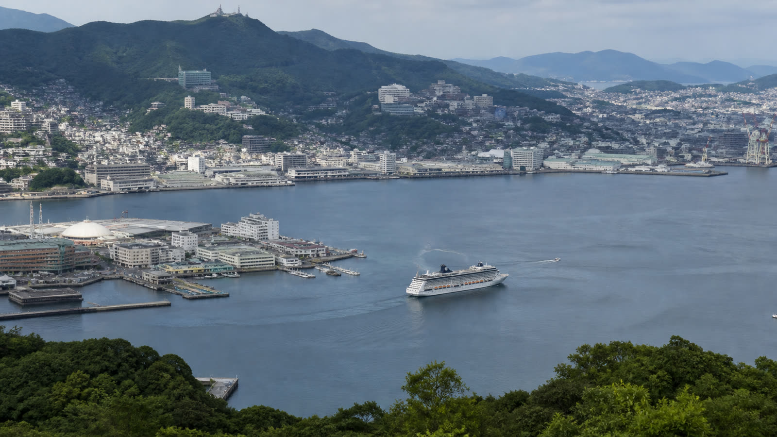 Nagasaki cruise harbor enclosed by green hills with an unbranded ship