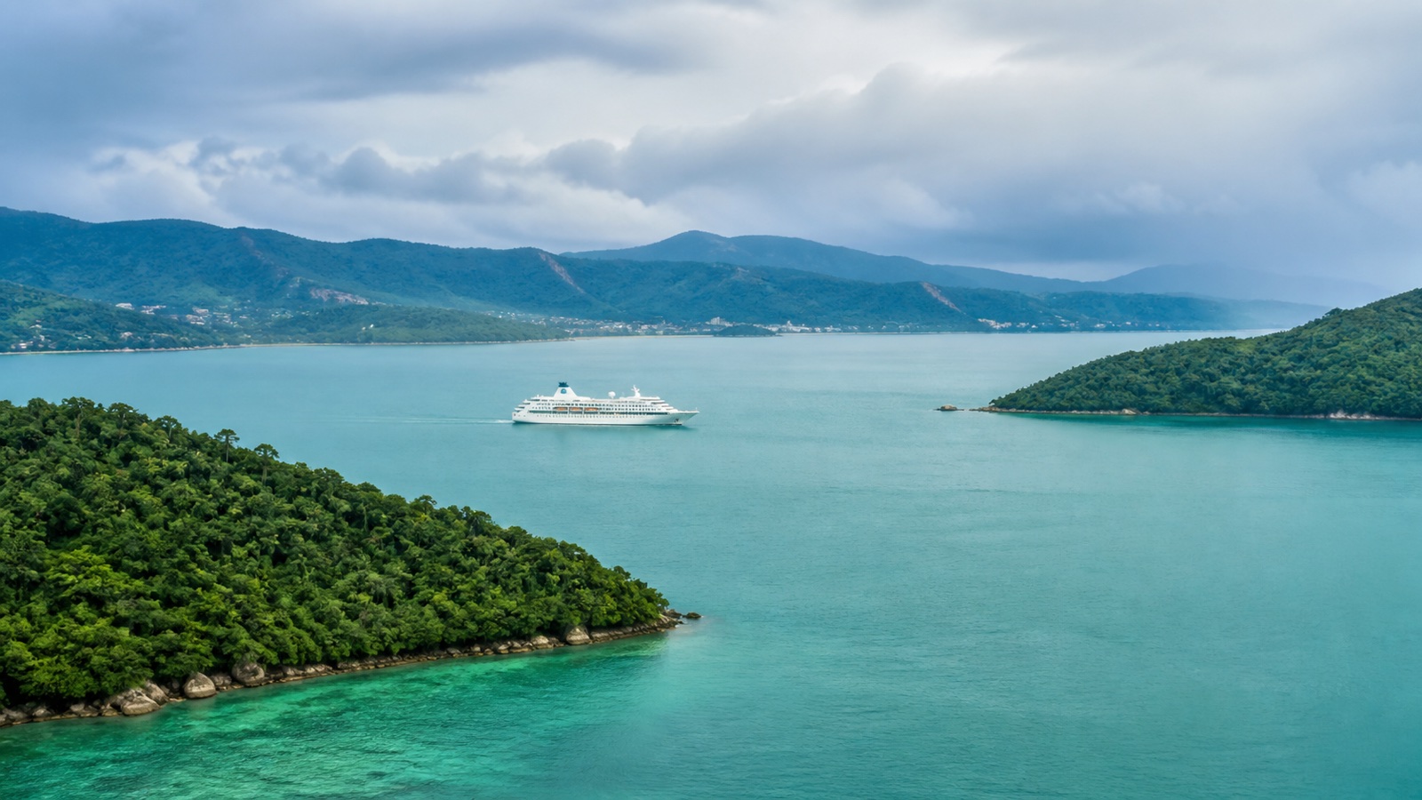 Unbranded cruise ship sailing between tropical Southeast Asian islands under humid daylight