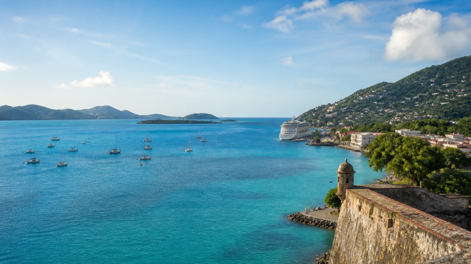 Eastern Caribbean harbor with a cruise ship, green hills and a waterfront town