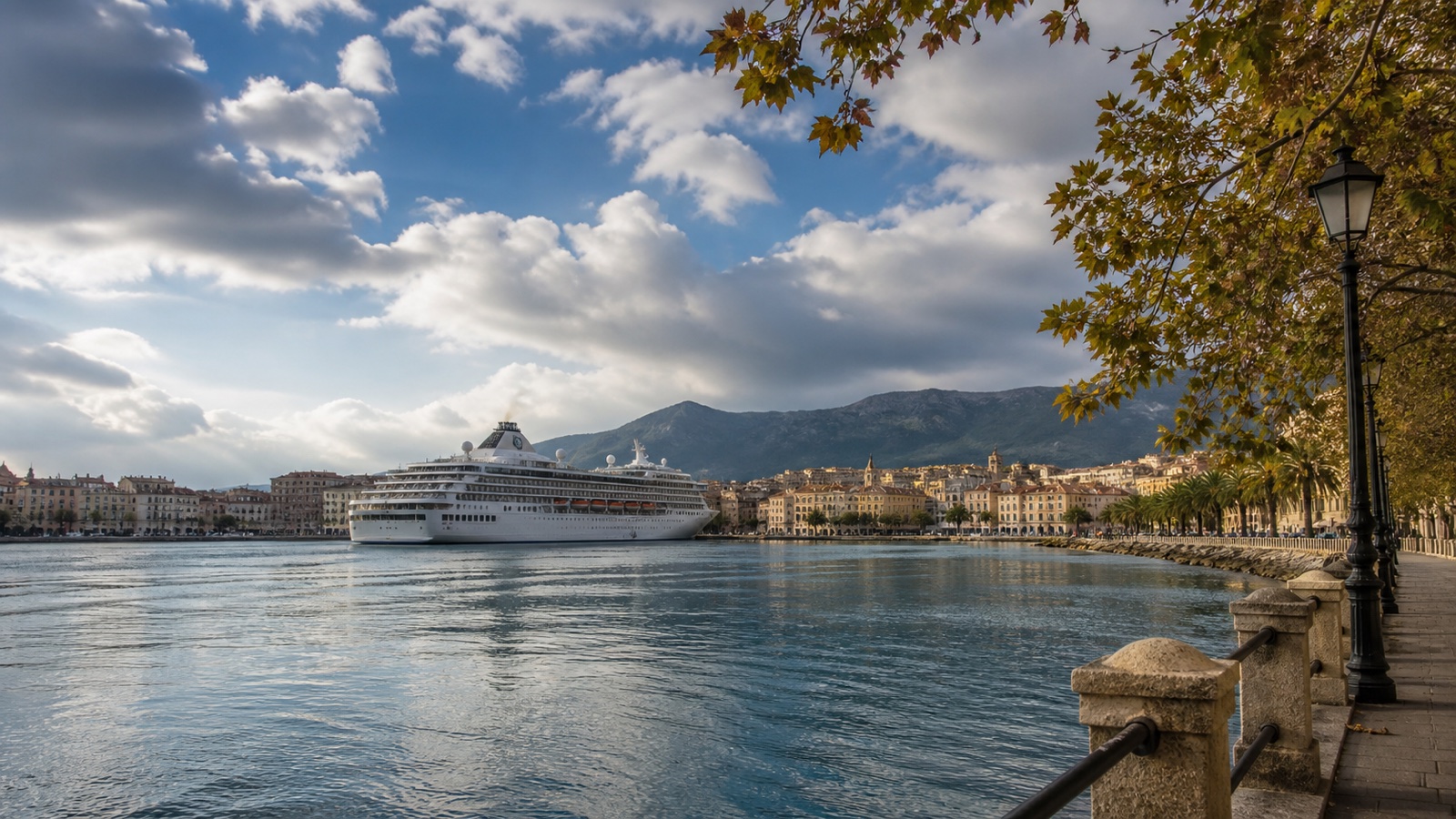 Mediterranean harbor in shoulder-season light beneath changing clouds
