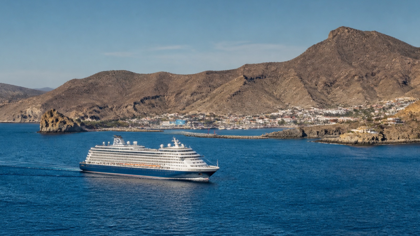 Unbranded cruise ship off a dry Baja California coast with a realistically scaled waterfront