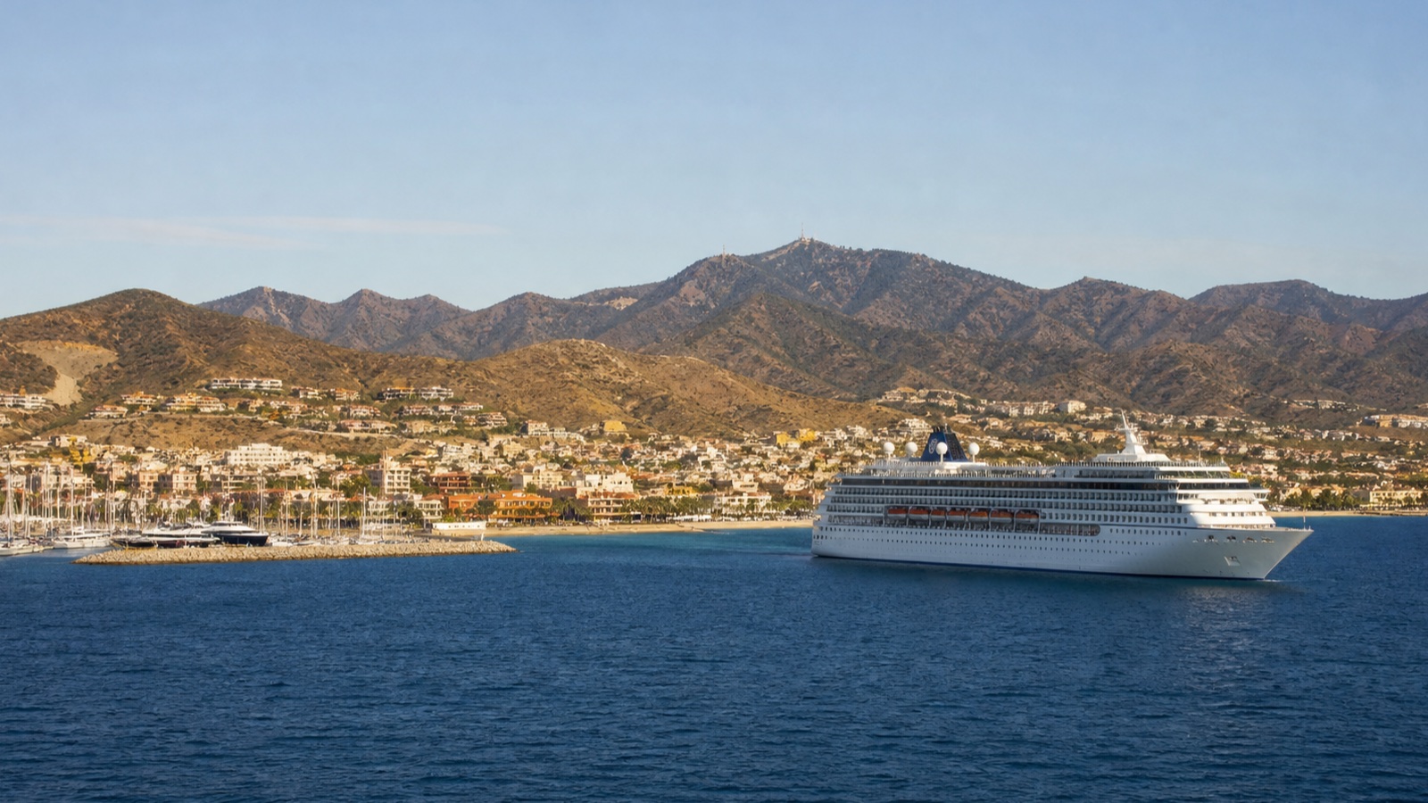 Unbranded cruise ship approaching a warm Mexican Riviera harbor at a realistic scale