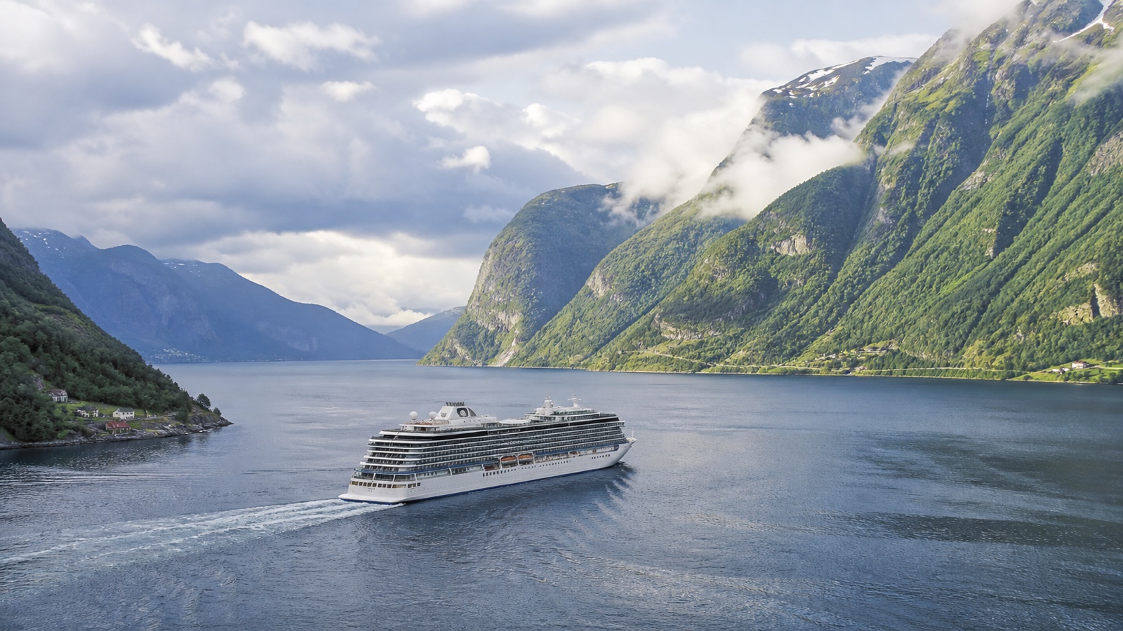 Unbranded cruise ship sailing through a broad Northern European fjord