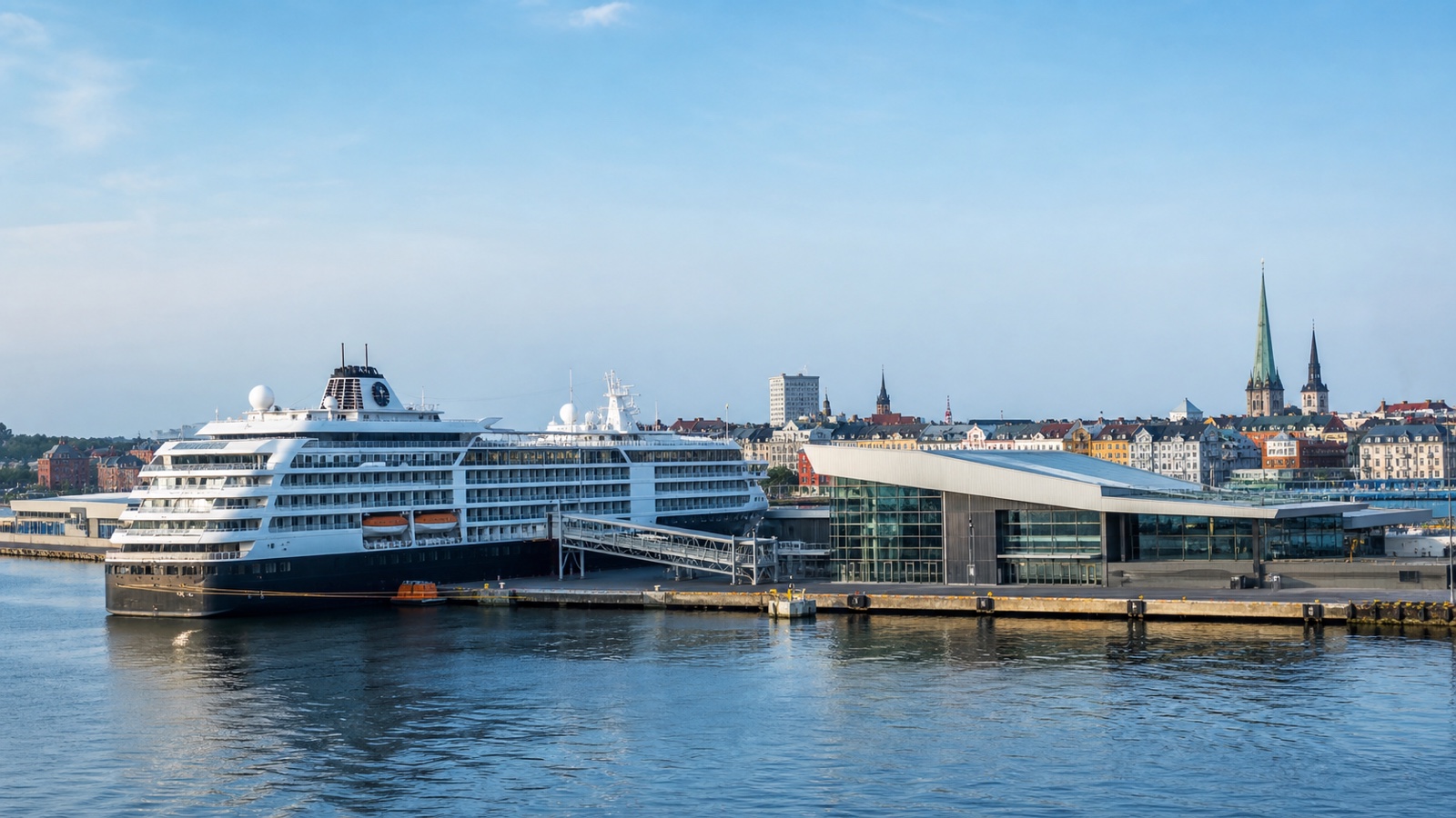 Northern European cruise terminal with an unbranded ship and city beyond