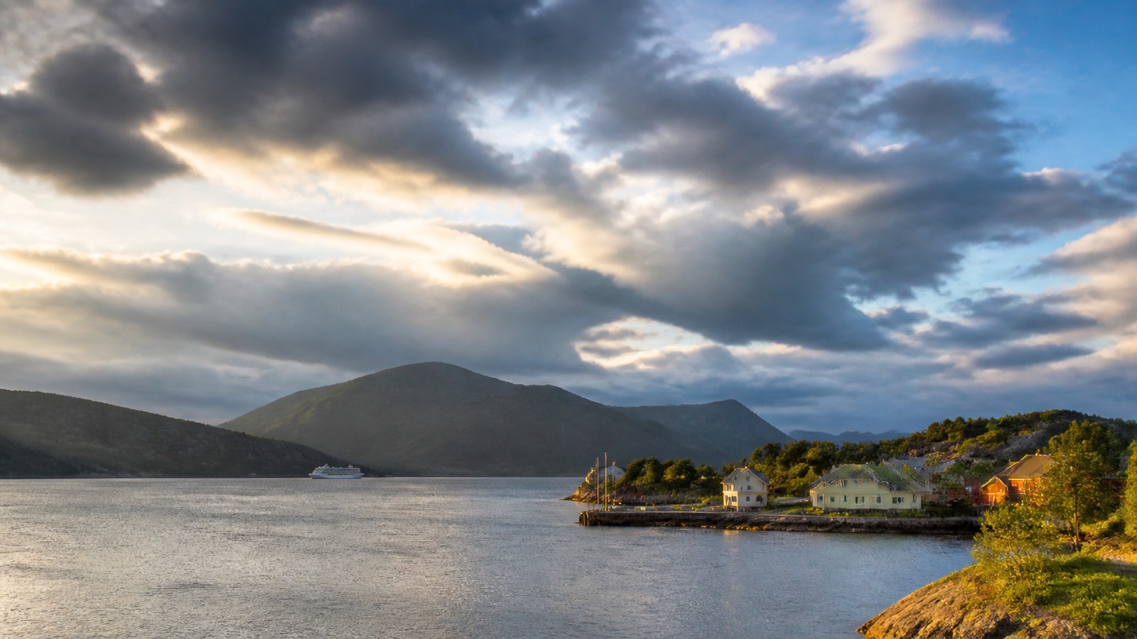 Northern European harbor beneath broken clouds and long summer light