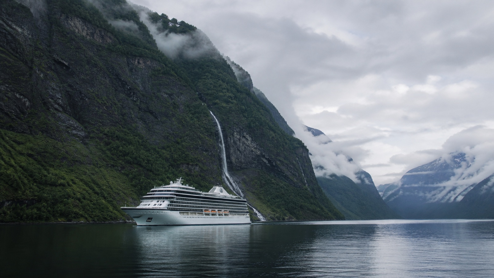 Unbranded cruise ship beneath steep green mountains in a Norwegian fjord