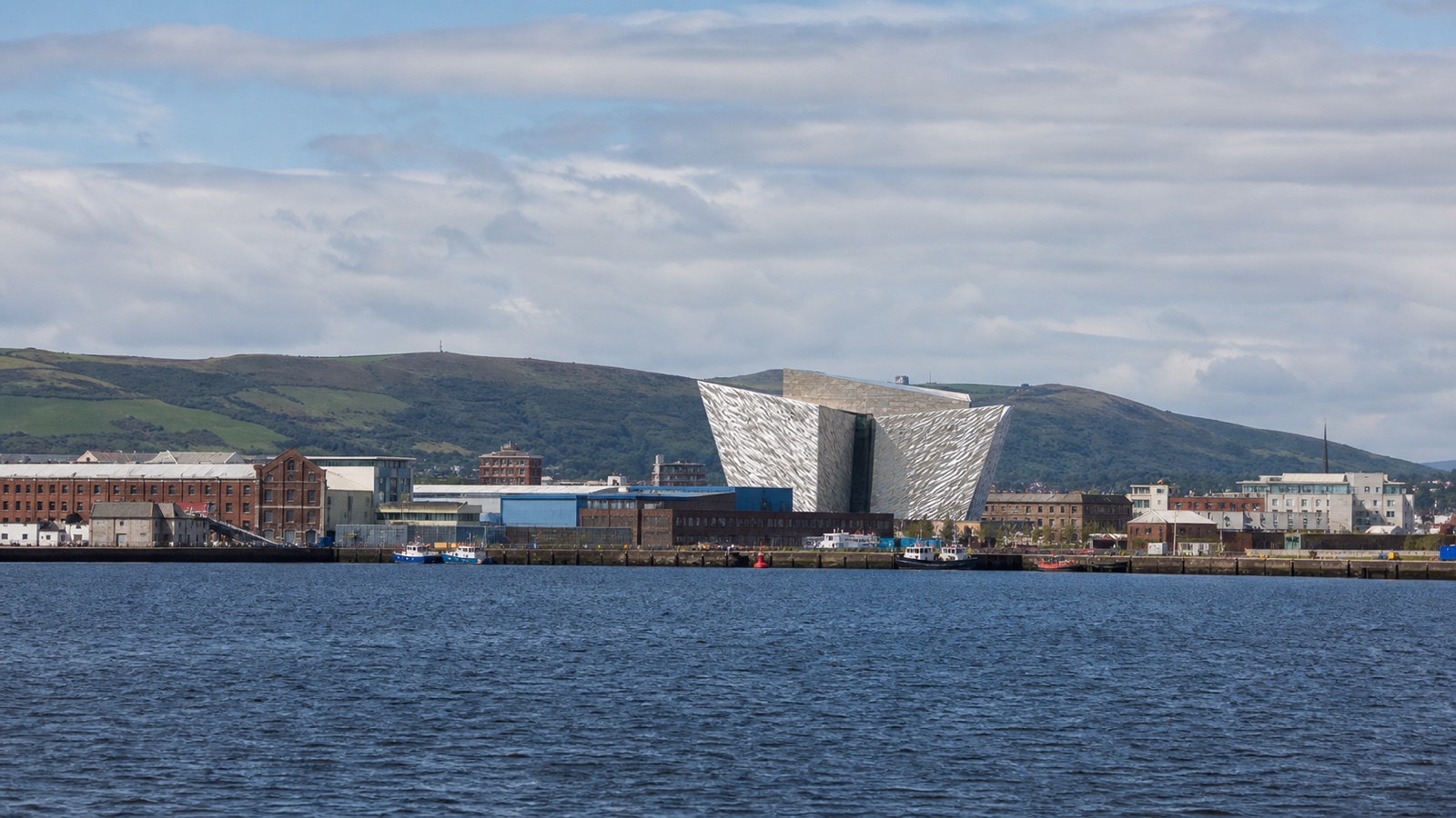 Belfast cruise harbor with city and green hills beyond