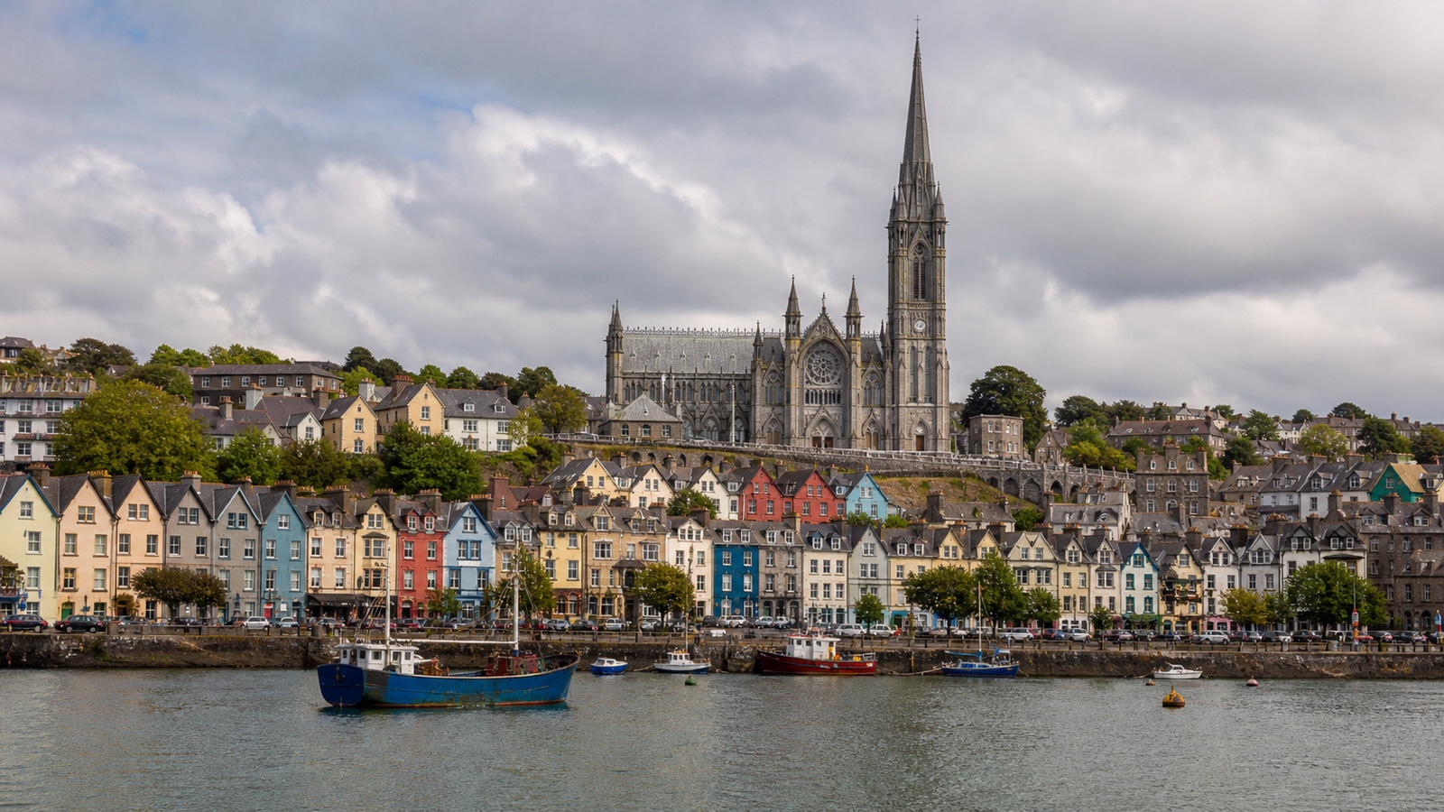 Cobh waterfront and cathedral above Cork Harbour with an unbranded ship