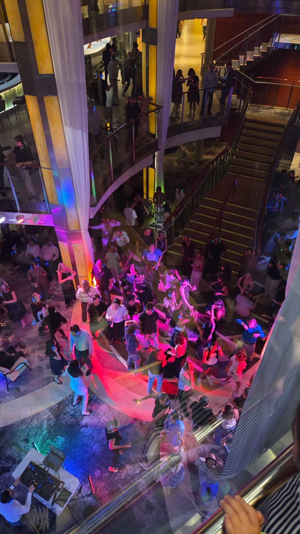 Passengers dancing in the multilevel atrium aboard Celebrity Solstice at night