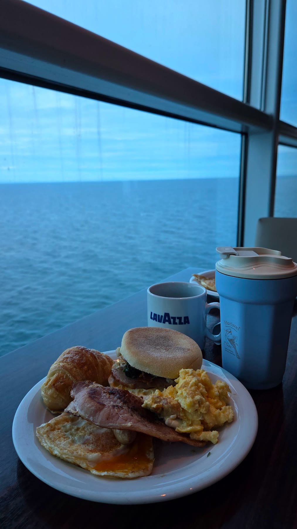 Breakfast set beside a large ocean-facing window aboard Celebrity Solstice