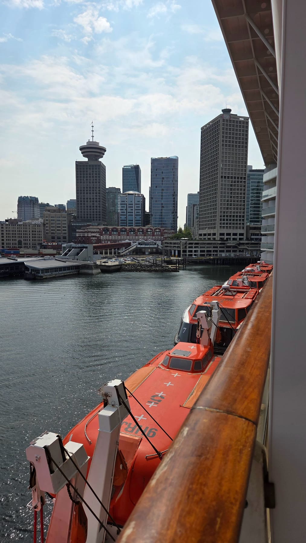 Vancouver skyline and orange lifeboats viewed from Celebrity Solstice on embarkation day