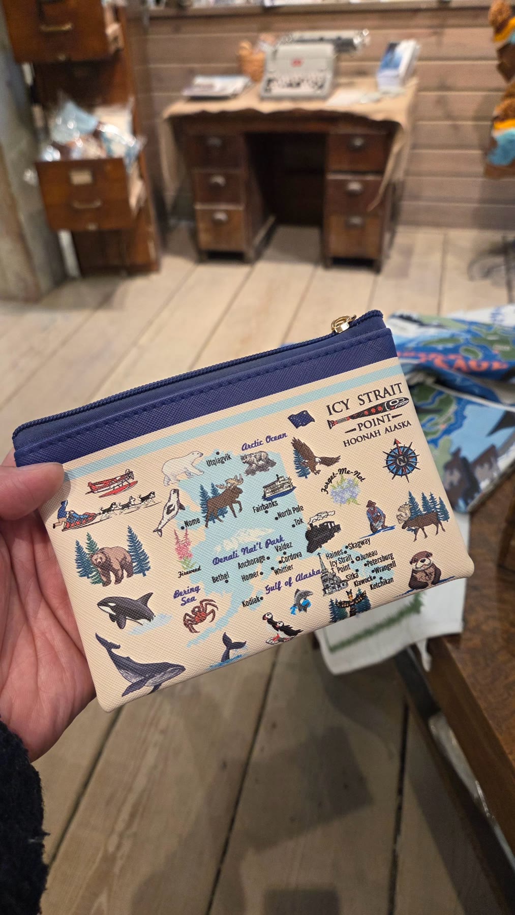 An Alaska wildlife souvenir pouch held inside a shop at Icy Strait Point