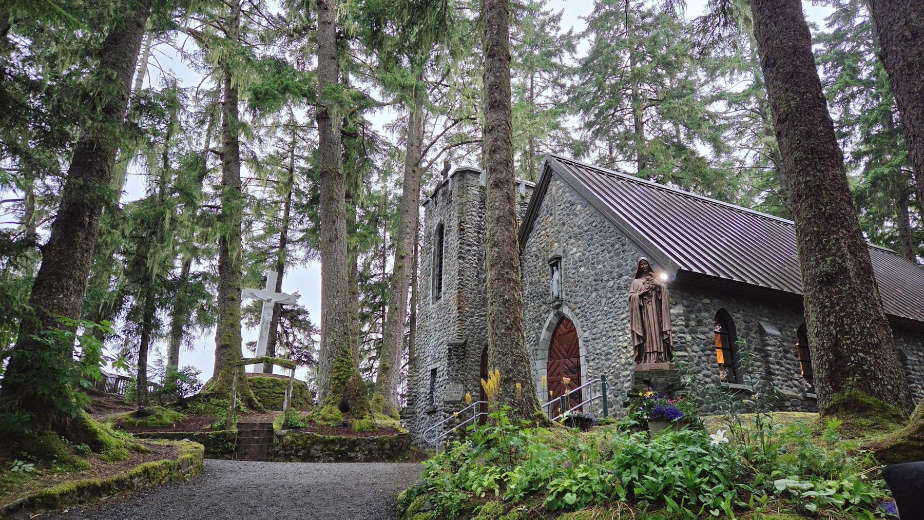 Stone chapel of the National Shrine of Saint Therese among mossy spruce trees