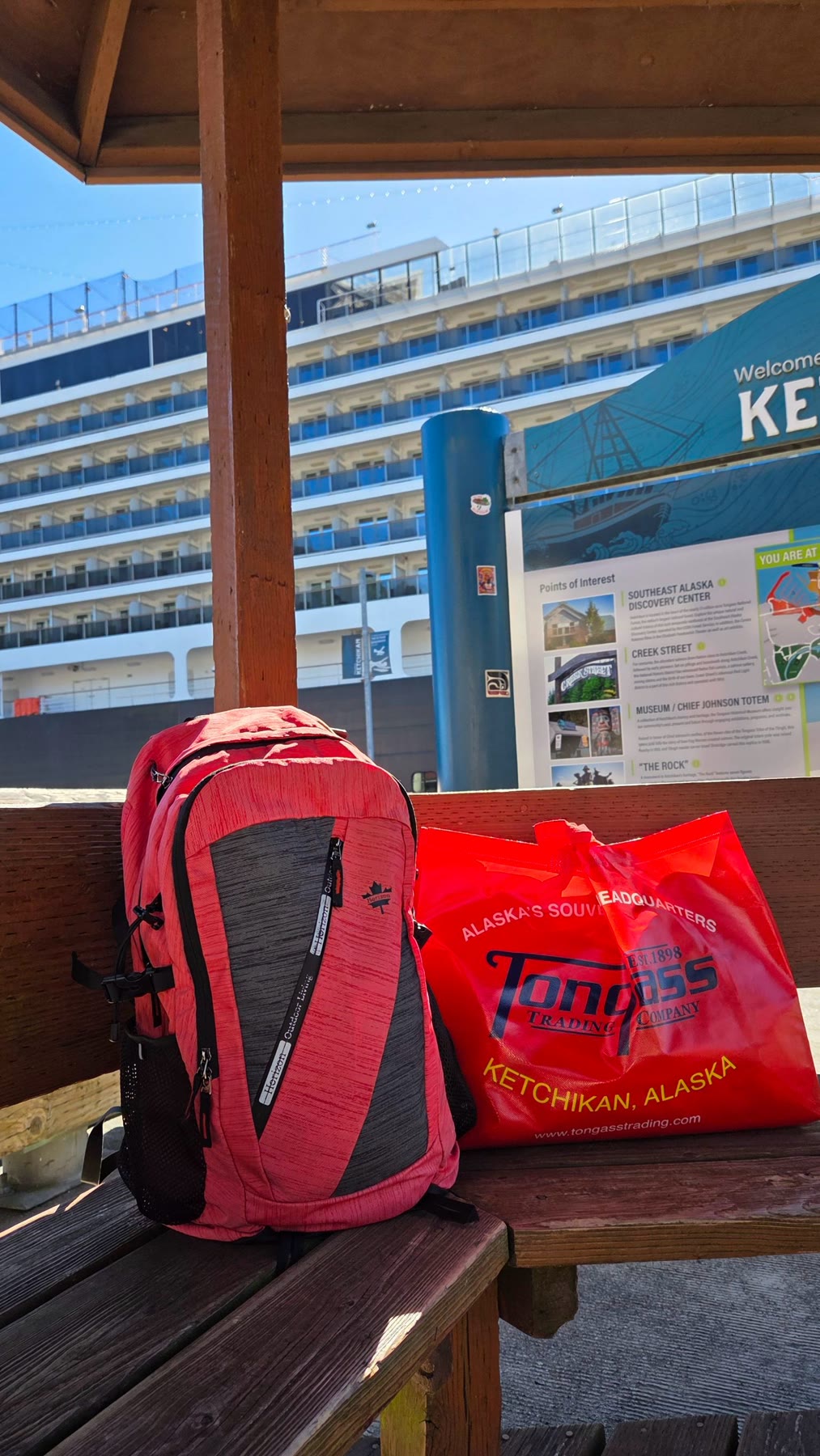 Backpack and red souvenir-shopping bag near the Ketchikan cruise dock
